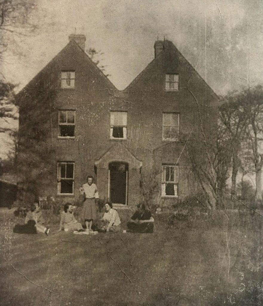 old photo of a house and a family